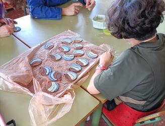 Alumnos realizando medallas para un evento del Proyecto Barrio al que pertenecemos.