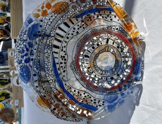 Pieza realizada en vidrio de 3 mm. Posee cortes superpuestos tipo mosaiquismo. Esmaltado con grisallas, micas y polvo de vidrio previo delineado con grisalla negra.