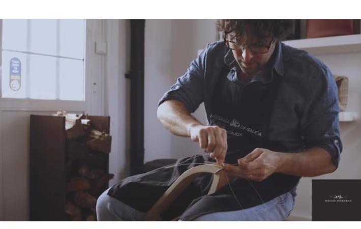 Artesano marroquinero cosiendo a mano.