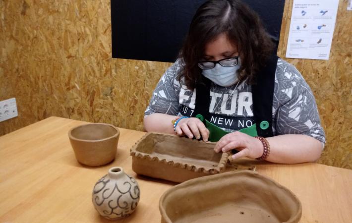 Artesana del taller elaborando diversas piezas de barro