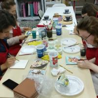 Alumnos y alumnas pintando azulejos