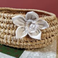 Cestito tejido con rafia decorado con flor de tela e hilo de algodón. 