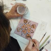 Proceso de decoración de azulejo con motivos florales. 