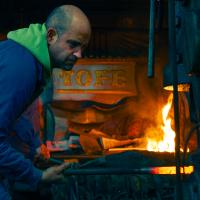 Foto en la que aparece Daniel Tofé en proceso de forjado con martillo pilón. Fotografía de Jonatan Narro