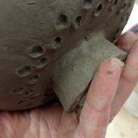 mano trabajando una pieza de gres